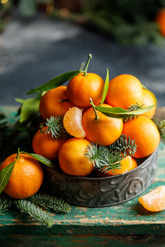 Christmas tangerines in metal box with christmas decorations on dark background. Christmas concept 