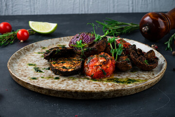 Grilled vegetables eggplant, sweet pepper, onion and champignon mushrooms on a plate.