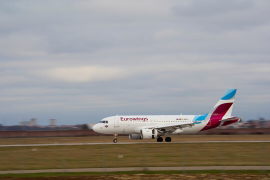 Arrival of Eurowings airline plane on the runway of Stuttgart International Airport. Panning shot. Stuttgart, Germany.