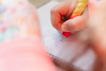 close-up of a girl's hand with a pen doing school maths. Concept of education