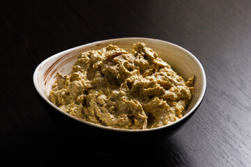 Satsivi, a Georgian poultry dish in a walnut sauce. Close-up of whore Satsivi on a dark background