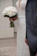 white wedding bouquet in the hands of the bride