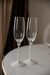 a pair of white classic wedding glasses for the bride and groom on the table