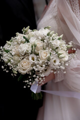 white wedding bouquet in the hands of the bride