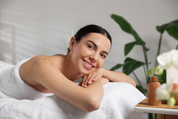 Obraz na płótnie Canvas Beautiful happy woman relaxing on massage table in spa salon