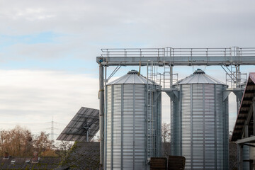 Obraz premium German farm with grain silo and solar panels. Modern sustainable agriculture in the German countryside.