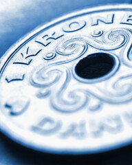 1 Danish krone coin close-up. National currency of Denmark. Blue tinted money illustration for news about economy or finance. Bank and loan. Savings and interest. Vertical stories. Macro