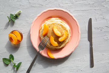 Tasty homemade pancakes with fresh peaches and honey, top view. 