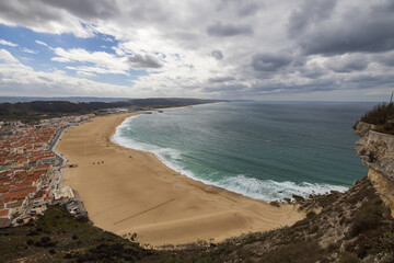 High angle view of the south beach of Nazaré, Portugal with the harbor and ocean