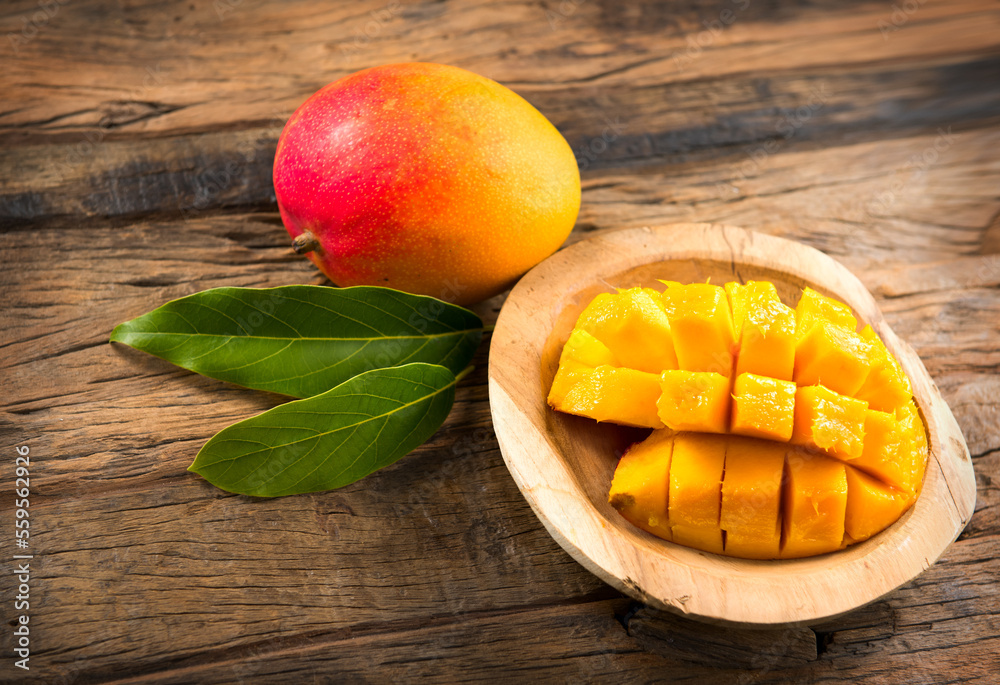 Sticker Mango fruit. Ripe Mango fruits over wood background. Close-up of fresh juicy tropical mango ready to eat, healthy sweet dessert, vegan food. 