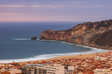 Long exposure shot of the city of Nazaré, the beach, cliffs and the fort of São Miguel Arcanjo