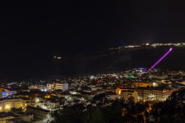 Naklejka premium Night view of the city of Nazaré, the beach, cliffs, funicular and the fort of São Miguel Arcanjo
