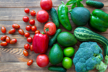 Assortment of green and red vegetables on wooden background, top view. 