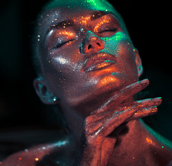 Fashion model woman skin face in bright sparkles, colorful neon lights, beautiful sexy girl portrait. Trendy glowing colorful skin make-up. Art design make up. Glitter metallic shine golden makeup