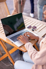 Happy student with laptop looks at you