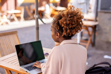 Happy student with laptop looks at you