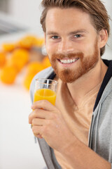 Fototapeta premium young man drinking orange juice at home