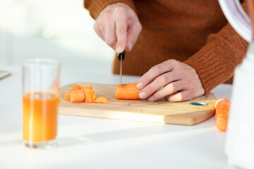 cropped image of carrot being chopped for juice - Powered by Adobe