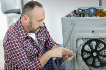 plumber with clipboard near washing machine