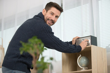 man adjusting his compact sound system in the home