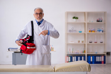 Old male paramedic working in the clinic