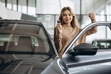 Woman holding keys by her new car