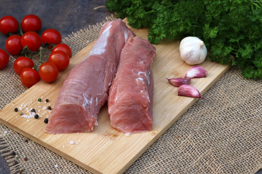 Rohes Schweinefilet mit Petersilie Tomaten und Knoblauch.	