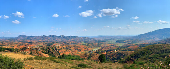 The landscape of Madagascar. Terraced rice fields, brown-orange villages, mountains in the...