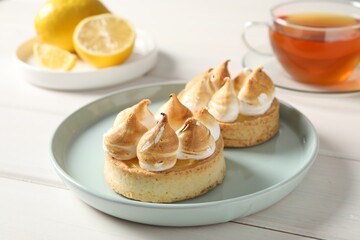 Delicious lemon meringue pies on white wooden table