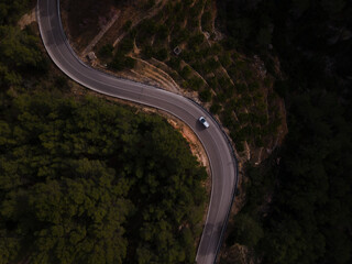 Aerial view of car driving down windy foggy road
