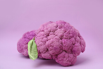 Whole fresh purple cauliflowers on violet background