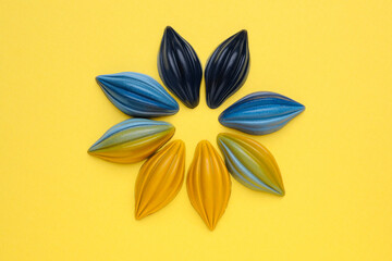 Tasty chocolate candies in shape of flower on yellow background, top view