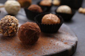 Different tasty chocolate candies on marble board, closeup