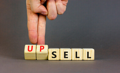 Sell or upsell symbol. Concept word Sell Upsell on wooden cubes. Businessman hand. Beautiful grey table grey background. Business Sell or Upsell concept. Copy space.