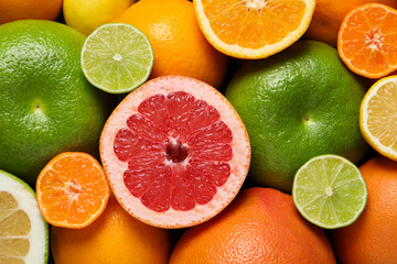 Different fresh whole and cut citrus fruits as background, top view