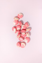 Pink and white French macarons isolated on a pink background