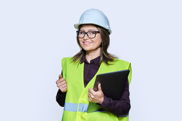 Portrait of engineer manager woman in helmet vest holding laptop