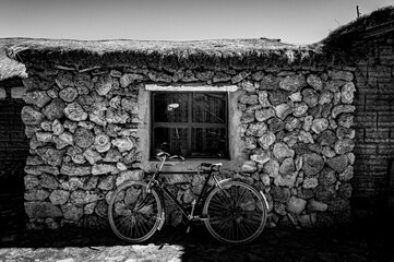 Fahrrad vor Steinhütte mit Strohdach