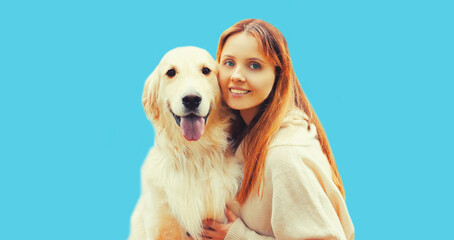 Portrait of happy smiling owner woman and Golden Retriever dog together on blue background