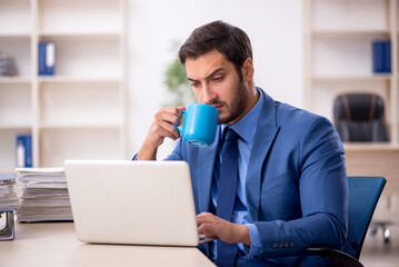 Young male employee and too much work in the office