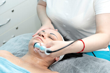 Naklejka premium Health. Cosmetology. An aged woman lies on a couch in a beauty salon for a facelift procedure.