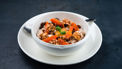 Oatmeal porridge with dried apricots, raisins and walnuts.
