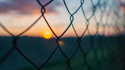 Beautiful colorful sunset through the fence