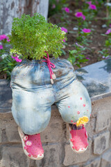 original plant pot from old children's jeans trousers. Scenery in a summer cafe. Reuse of products, needlework