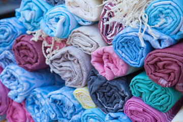 Multicolored Turkish bath towels, traditional hammam towels made from natural cotton, rolled in a roll at a street market in Bodrum