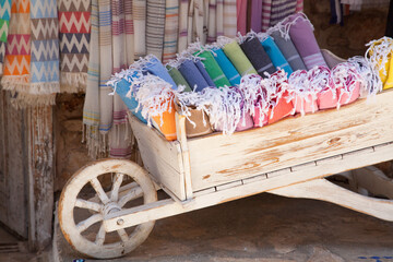 Multicolored Turkish bath towels, traditional natural cotton hammam towels in a wooden cart at a street market in Bodrum
