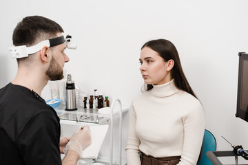 Visiting ENT doctor for examination of the state of health of the ear, throat and nose. Consultation of woman with otolaryngologist in a medical clinic.