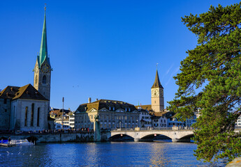 view from the bank of the Limmat river in Zurich to the old bridge and towers