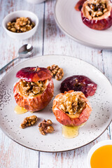 Homemade baked apples with walnuts and honey on the table. Vertical view