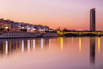 Sunset over the authentic neighborhood of Tirana in Seville with views on Calle Betis, Torre Sevilla and with awesome reflections in the river Guadalquivir, creating magic atmosphere and views